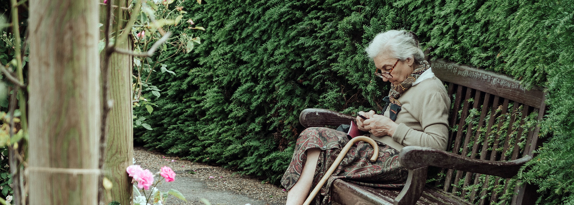 Anziana seduta su una panca in legno