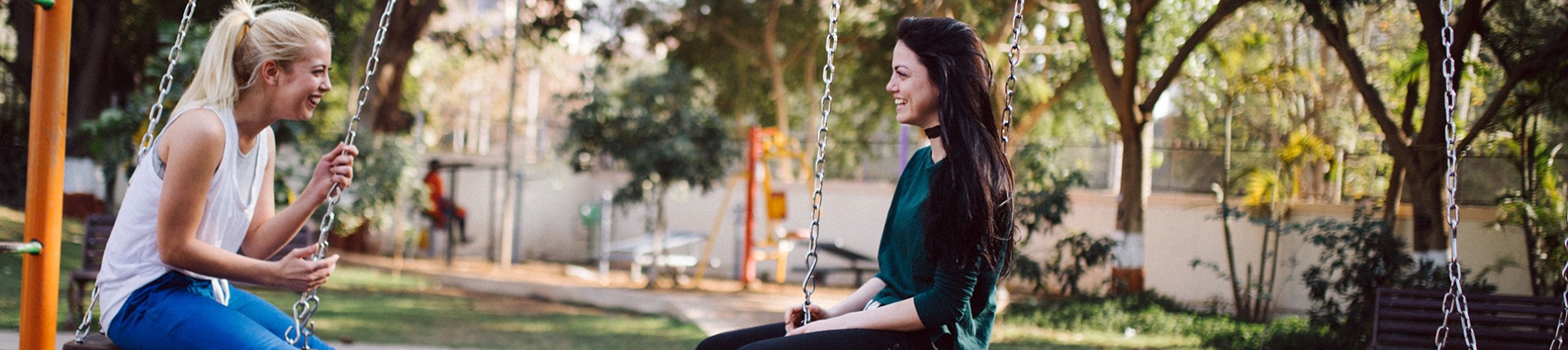 Giovani ragazze sulle altalene al parco Giovani ragazze sulle altalene al parco